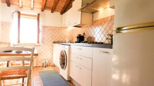 a kitchen with a washer and dryer in it at Cozy 18th century house in San Gimignano +41 photos