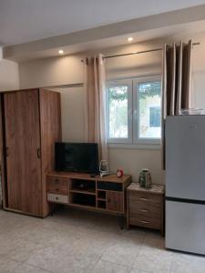 a living room with a television and a refrigerator at Ioana Sea View in Corfu