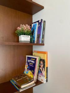 a book shelf with some books on it at Zahret Al Roman in Sayq