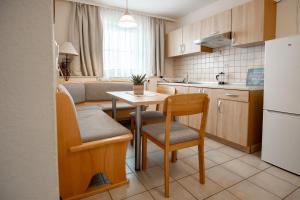 a kitchen with a small table and chairs and a refrigerator at Ferienwohnungen Steinbacher in Vogtareuth +16 photos