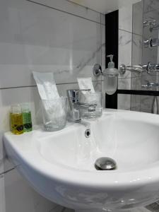 a white sink in a bathroom with a mirror at Guest house Kula in Kula +28 photos