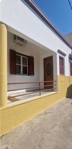 a yellow and white building with a window at Niki's Cozy Home in Kalymnos