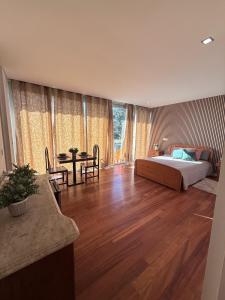 a living room with a bed and a table at Suíte com varanda e vista de mar in Valadares