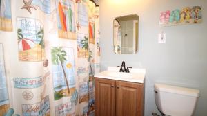 a bathroom with a sink and a toilet and a mirror at Relaxing Beginnings in Cape May Point +13 photos