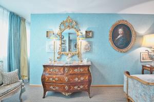 a bedroom with a dresser and a mirror on the wall at Historic Cinema Suite with Private Art Collection - Basel in Basel