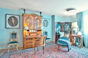 a living room with a wooden dresser and chairs at Historic Cinema Suite with Private Art Collection - Basel in Basel