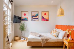 a bedroom with a bed and some pictures on the wall at Green Meadow Serenity - Center Hotel in Da Lat +40 photos