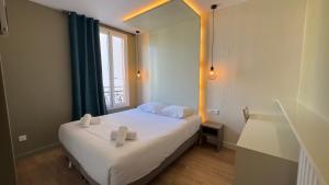 a bedroom with a bed with two towels on it at Alma Hotel in Courbevoie