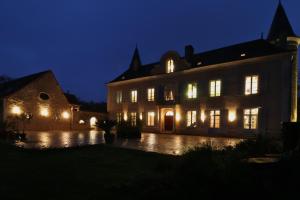 a large building with lit up windows at night at La Brosse Estate - Chateau de la Brosse in Lureuil