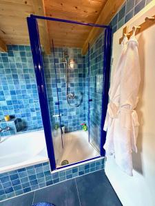 a bathroom with a tub and a shower with a mirror at Rosi's Ferienwohnung Kampenwandblick in Prien am Chiemsee +23 photos
