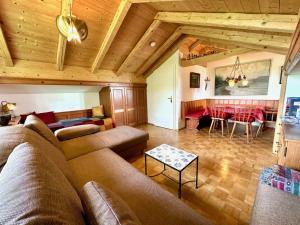 a living room with a couch and a table at Rosi's Ferienwohnung Kampenwandblick in Prien am Chiemsee