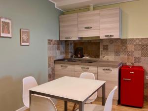 a kitchen with a table and a red refrigerator at Bixio 40, Alloggio Turistico in Montefiascone