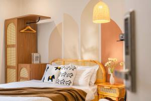 a bedroom with a bed with white sheets and pillows at Green Meadow Serenity - Center Hotel in Da Lat