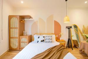 a bedroom with a bed with white sheets and pillows at Green Meadow Serenity - Center Hotel in Da Lat