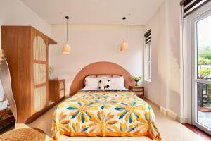 a bedroom with a bed with a colorful bedspread at Green Meadow Serenity - Center Hotel in Da Lat