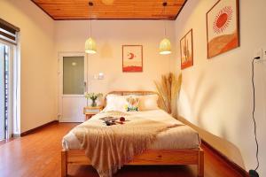 a bedroom with a bed and two pendant lights at Green Meadow Serenity - Center Hotel in Da Lat