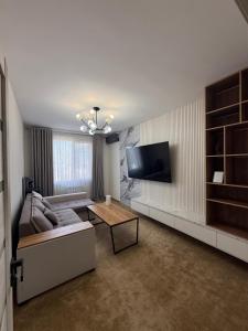 a living room with a couch and a flat screen tv at Olmazor Comfort in Qoraqamish