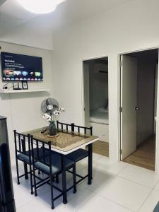 a dining room with a table and chairs and a bedroom at NagaCityRiverView 2BR Apartment in Naga