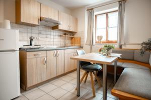 a small kitchen with a table and a refrigerator at Ferienwohnungen Steinbacher in Vogtareuth
