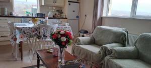 a living room with a table with a vase of flowers at Doolin Farm Apartment in Doolin +24 photos