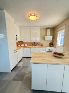 a kitchen with white cabinets and a bowl of fruit on a counter at Cozy Villa With Pool In Marbella Nueva Andalucia in Marbella