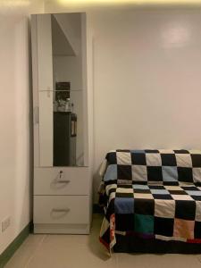a room with a bed and a cabinet with a sink at Bright Nook in Manila
