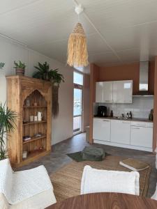 a kitchen with white cabinets and a chandelier at RetreatBoat Bali in Lithoijen