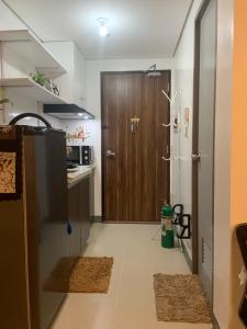 a kitchen with a brown door and a kitchen with rugs at Bright Nook in Manila
