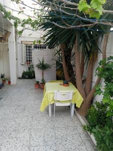 a table with a yellow table cloth on it in a courtyard at Tunisian style in La Marsa