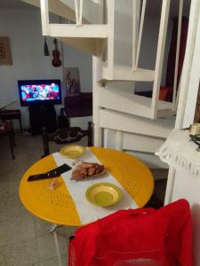 a yellow table with a plate of food on it at Tunisian style in La Marsa