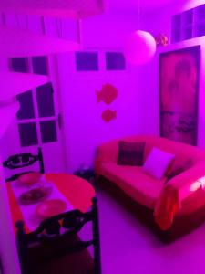 a living room with pink lighting and a couch and a table at Tunisian style in La Marsa +4 photos