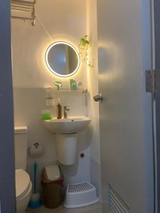 a bathroom with a sink and a mirror and a toilet at Bright Nook in Manila +5 photos