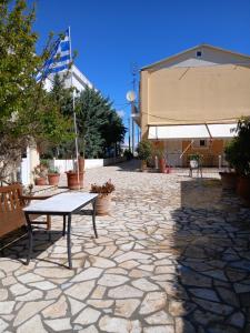 a table and a bench on a stone patio at Ioana Sea View in Corfu +5 photos