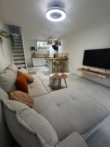 a living room with a couch and a flat screen tv at Charmant Appartement Grand Gosier in Le Gosier