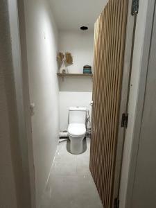 a bathroom with a white toilet in a hallway at Charmant Appartement Grand Gosier in Le Gosier +4 photos
