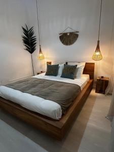 a large bed in a room with two lights at Charmant Appartement Grand Gosier in Le Gosier