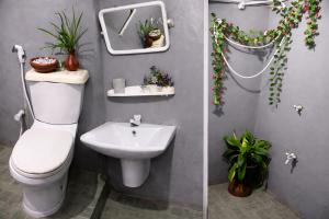two pictures of a bathroom with a toilet and a sink at Solar House Hotel in Dickwella