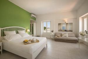 a bedroom with a white bed and a green wall at Isola Charm B&B - Pool & Nature Stay in Syracuse