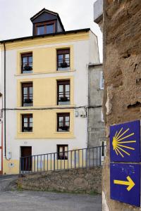 a yellow and white building with a sign in front of it at A Casa da Ponte in Lugo