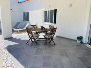 a patio with a wooden table and chairs at Casa da praia in Aljezur +19 photos