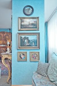 a blue wall with paintings and a couch in a room at Historic Cinema Suite with Private Art Collection - Basel in Basel +46 photos