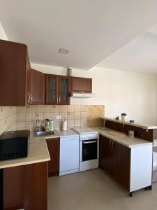 a kitchen with brown cabinets and white appliances at Bela Rada in Tivat