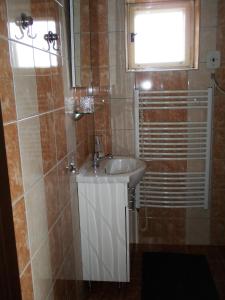 a bathroom with a white sink and a window at Ubytování u Přadků in Čeladná