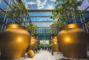 a row of large gold vases in front of a building at Kameha Grand Bonn in Bonn