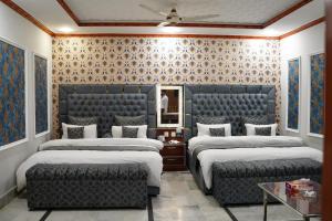 a room with three beds and a mirror at Hotel Grand Orchard in Lahore +131 photos