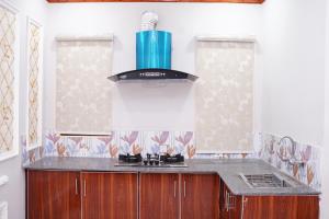 a kitchen with a stove with a blue vase at Hotel Grand Orchard in Lahore