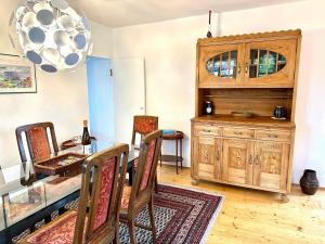 a dining room with a table and a wooden cabinet at Rosi's Ferienwohnung im Haus Sieglinde in Prien am Chiemsee