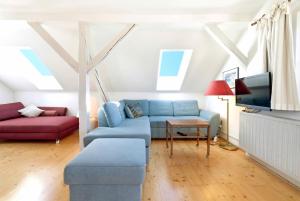 a living room with a blue couch and a tv at Rosi's Ferienwohnung im Haus Sieglinde in Prien am Chiemsee
