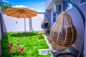 a patio with an umbrella and a chair and a table at Uhondo Apartments in Dodoma