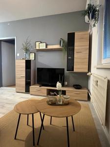 a living room with a table and a tv at Harmony Apartman in Dunajská Streda